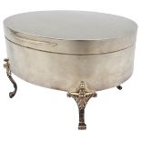 A SILVER JEWELLERY CASKET, simplistic oval form with plush lined interior, raised on four