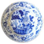 A BLUE & WHITE DELFT PLATE, 18TH CENTURY, depicting a peonie in a traditional garden scene, the