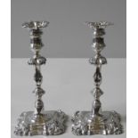 A PAIR OF WILLIAM IV SILVER CANDLESTICKS, campana form sconces sat atop knopped, foliate banded