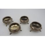 A SET OF FOUR VICTORIAN SILVER SALTS, circular form, gadrooned rim with floral repousse