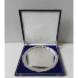 A SILVER SERVING TRAY, circular form with gadrooned scroll edge, bears the mark of J B Chatterly &