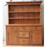 AN EARLY 19TH CENTURY WAXED PINE DRESSER, in two sections, a moulded cornice plate rack with two