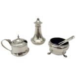 A SILVER CRUET SET, wide waisted tapered form, consisting of a salt cellar with two spoons, a pepper