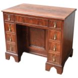 A GEORGE III MAHOGANY WRITING DESK, CIRCA 1820, long frieze drawer above a central recessed cupboard