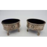 A PAIR OF GEORGE III OVAL SILVER SALTS, with blue glass liners, beaded rims, chased foliate