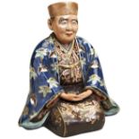 JAPANESE PORCELAIN FIGURE MEIJI / TAISHO PERIOD modelled as a kneeling man wearing a long flowing