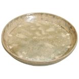 A YUEYAO CELADON DISH EASTERN JIN DYNASTY (AD316 - 420) the well potted dish covered all over in a