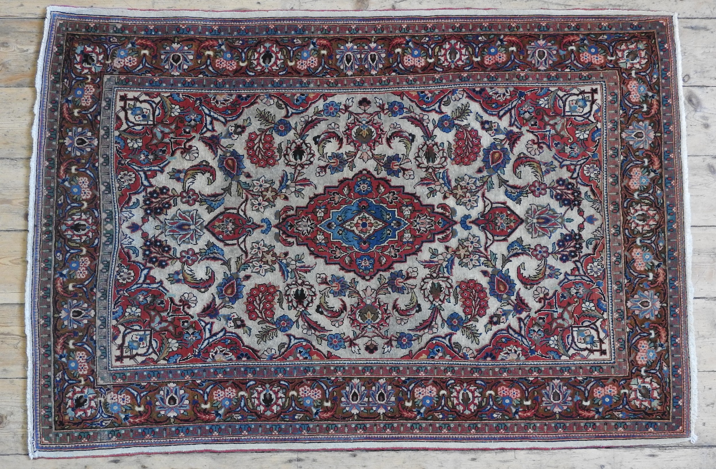 A HAND KNOTTED KASHAN RUG, 20TH CENTURY, central medallion surrounded with a profusion of