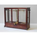 A SET OF 19TH CENTURY LABORATORY SCALES, in a glass panelled mahogany case with two glazed doors