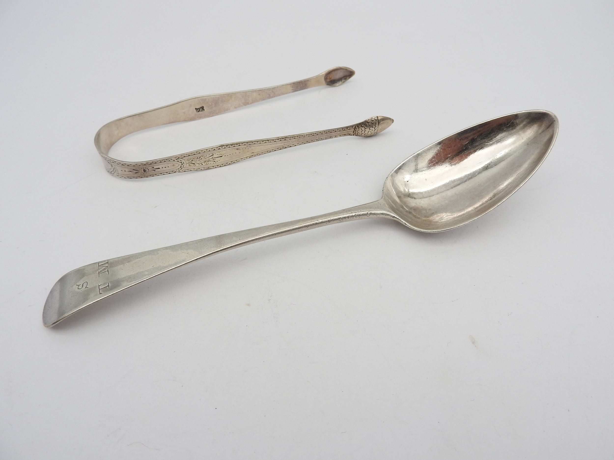 A PAIR OF GEORGE III SILVER SUGAR TONGS AND A TABLESPOON, BOTH BY HESTER BATEMAN, the pair of