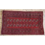 A HAND KNOTTED BOKHARA RUG, 20TH CENTURY, deep border pattern on a red ground 182 x 105 cm