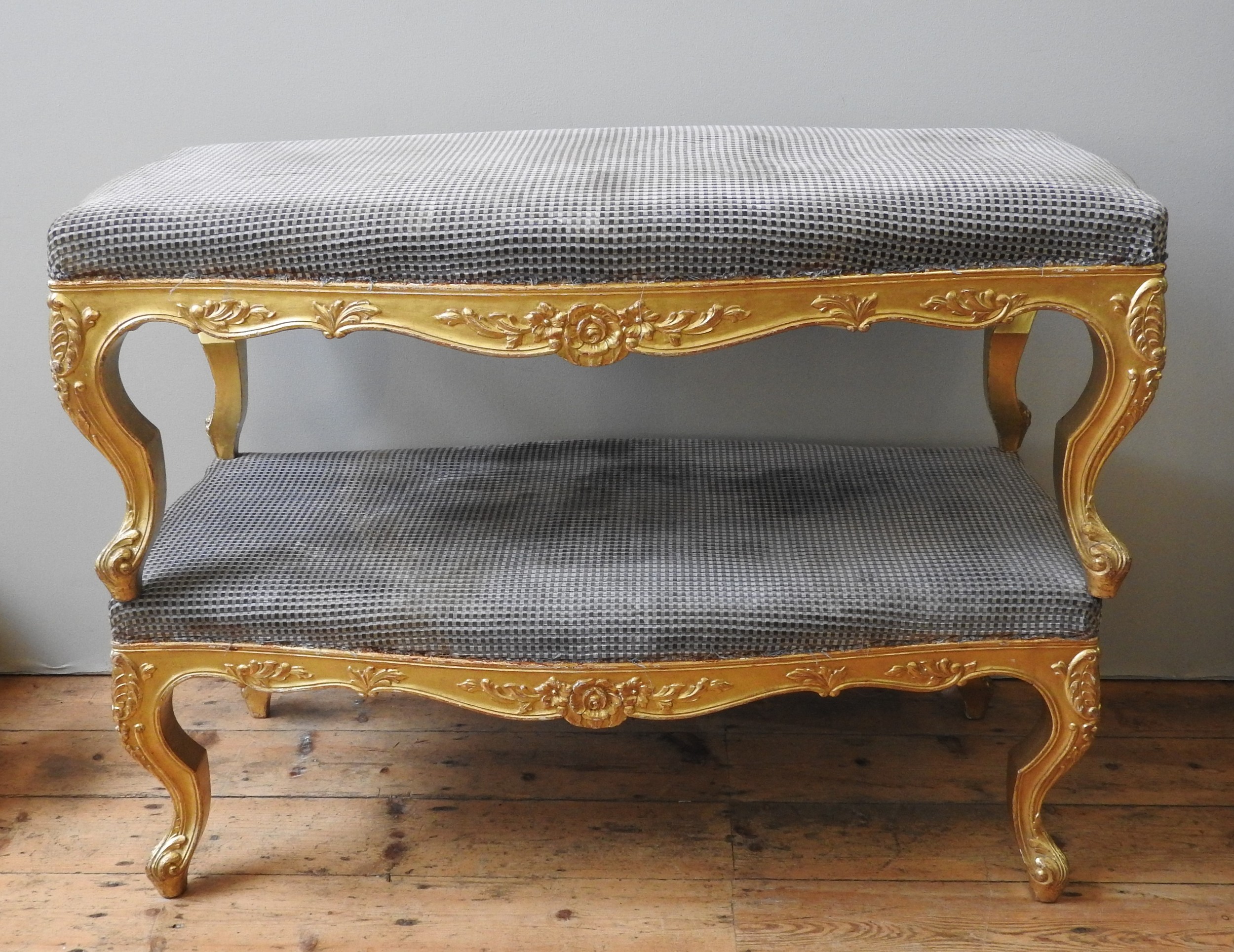 A PAIR OF LARGE REGENCY STYLE GILT FRAMED STOOLS, EARLY 20TH CENTURY, serpentine form, large