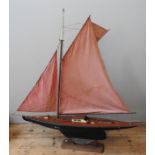 A LARGE VINTAGE POND YACHT, EARLY 20TH CENTURY, with mast, booms, twin sails, a mahogany deck and