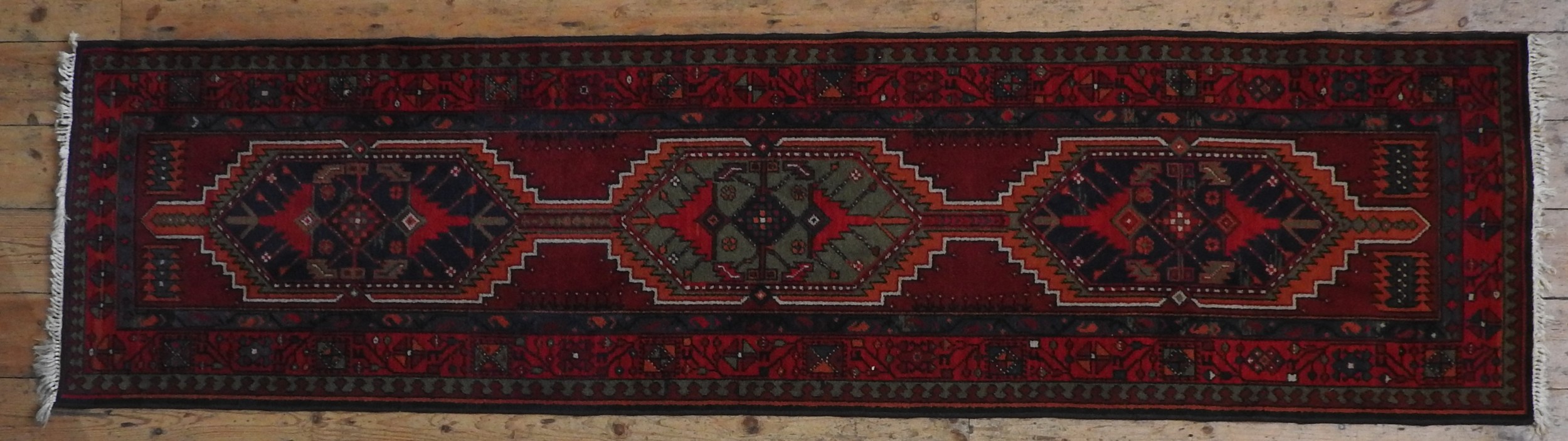 A HAND KNOTTED PERSIAN HAMADAN RUNNER, 20TH CENTURY, three central medallions within a deep