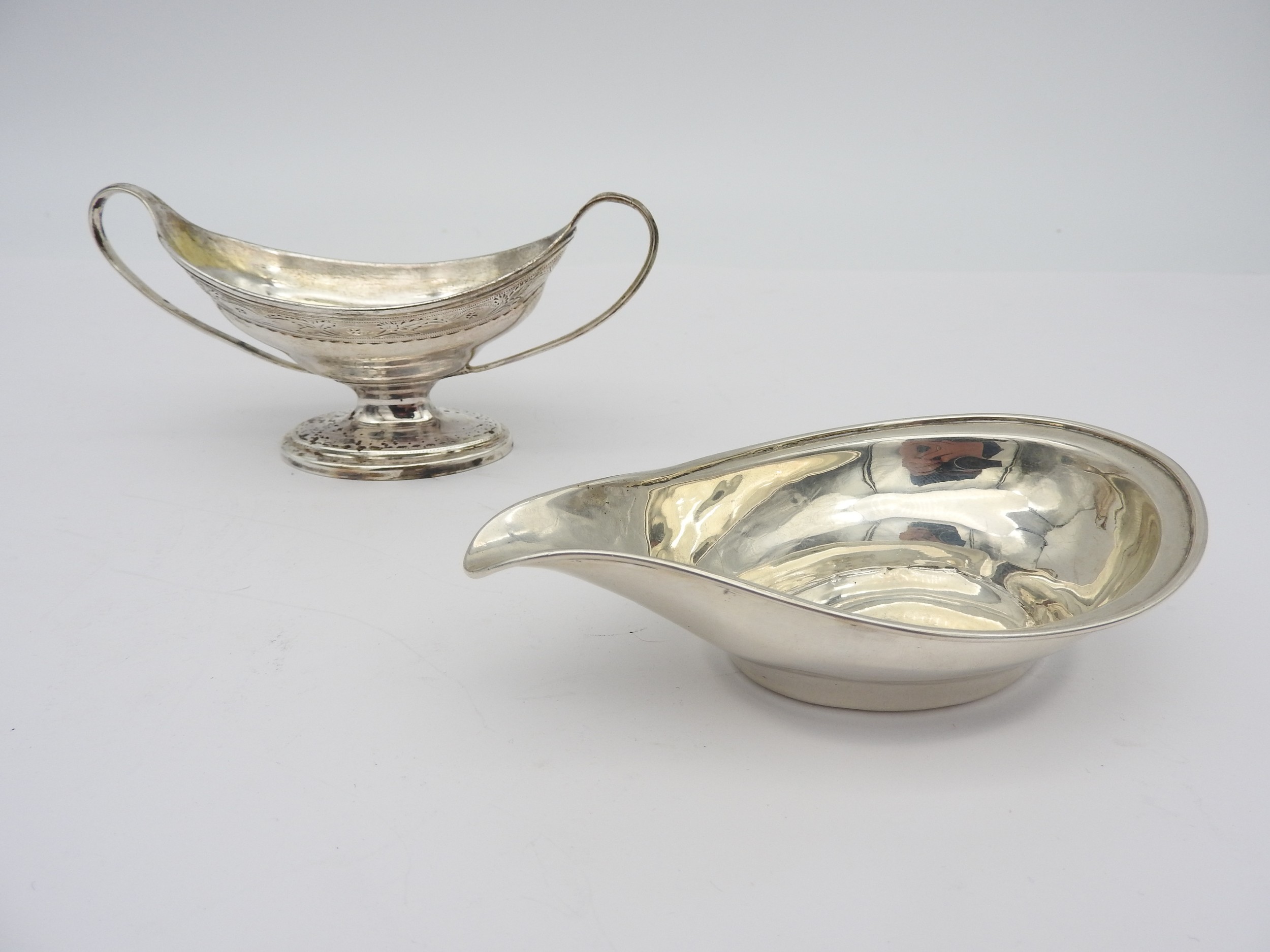 A GEORGE III SILVER TWO HANDED SALT AND A SILVER PAP BOAT, the elegant salt of oval form with bright