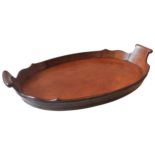 A GEORGE III MAHOGANY COOPERED TRAY, oval form with two scroll handles and shaped gallery edge 63