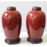 A PAIR OF SANG DE BEOUF GLAZED COVERED JARS VASES WITH STANDS, LATE QING DYNASTY, covered in a