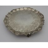 A GEORGE III SILVER SALVER, circular form with scroll edge, with blossoming stems chased