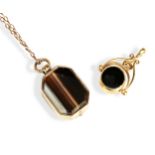 A 9CT GOLD AND HARDSTONE SPINNING FOB AND A VICTORIAN AGATE INSET YELLOW METAL LOCKET, the octagonal