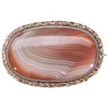 AN AGATE AND GOLD BROOCH, CIRCA 1840 the oval agate plaque within a chased foliate border. Brooch