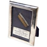 A SMALL SILVER PRAYER HOLDER MOUNTED IN A FRAME WITH A SILVER PRESENTATION PLAQUE engraved ‘To