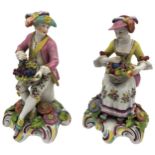 A PAIR OF SAMSON FIGURINES, EARLY 20TH CENTURY depicting seated lady and gentleman holding baskets