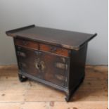 A SINGAPORE DARKWOOD SIDE CABINET, the top with rolled ends over two drawers and two doors with