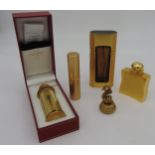 A GROUP OF FIVE PERFUME BOTTLES, including two Cartier atomisers, a Hermes atomiser modelled as a