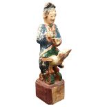 AN CHINESE CARVED WOODEN POLYCHROME FIGURE, EARLY 20TH CENTURY, of a robed attendant holding a tea