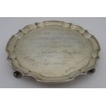 A SILVER PRESENTATION SALVER, circular form with scroll edge, inscribed with dedication and
