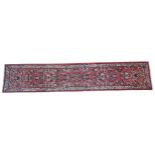 A HAND KNOTTED PERSIAN HALL RUNNER, 20TH CENTURY, decorated with floral sprays within a floral
