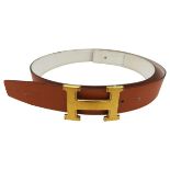 A HERMES ORANGE LEATHER BELT with gilt H buckle, boxed.