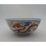 A WUCAI-STYLE CHINESE BOWL, 20TH CENTURY, the sides decorated with iron-red scaly dragons amongst