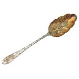 A GEORGIAN SILVER BERRY SPOON, repousse decorated scolloped edge bowl with ornate bright cut handle,