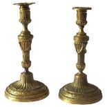 A NEAR PAIR OF FRENCH GILT BRONZE CANDLESTICKS, 19TH CENTURY, campagna form top section on fluted