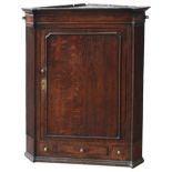 A 19TH CENTURY OAK CORNER CUPBOARD, a single panelled door enclosing three interior shelves, the