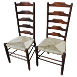 A PAIR OF PINE LADDER BACK CHAIRS, 20TH CENTURY, with rush covered seat panels, raised on turned