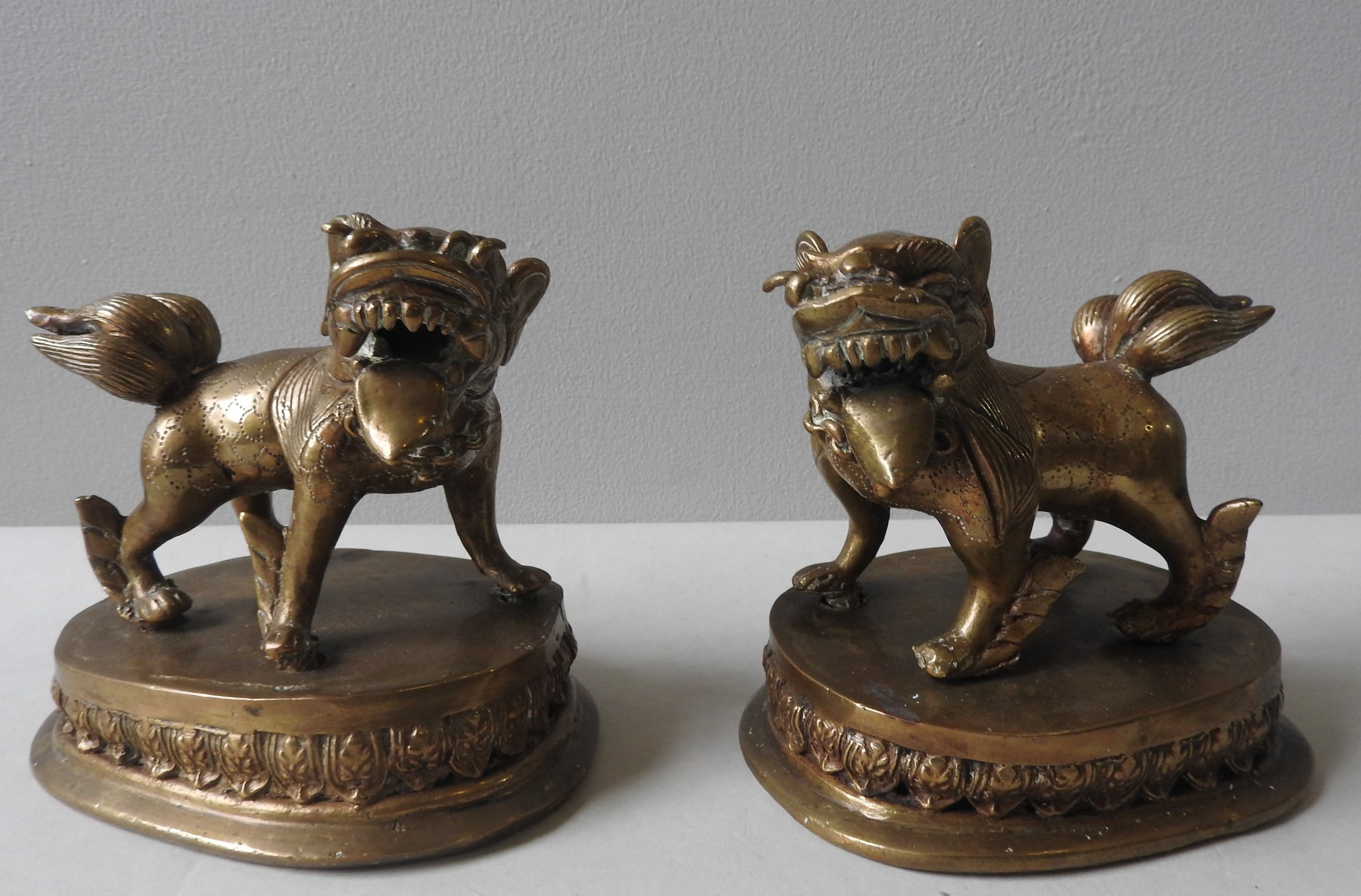 A PAIR OF LAQUERED BRASS CHINESE LIONS, QING DYNASTY, standing foursquare on lotus bases 14 cm high