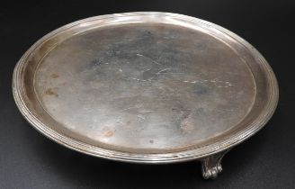 A GEORGE III SILVER SALVER, with reeded rim and engraved armorial crest, raised on three bracket