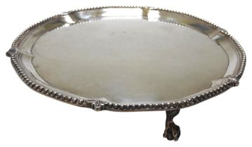 A GEORGE III SILVER SALVER, circular form with beaded scroll edge, raised on three claw and ball