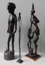 A CARVED PAPUA ASMAT FIGURE AND A CARVED MAKONDE GROUP FIGURE, along with a slender bronze figure 68