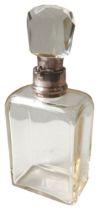 AN EDWARDIAN SILVER MOUNTED GLASS DECANTER, simplistic rectangular form with faceted stopper, the