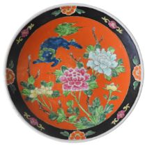 A 19TH CENTURY JAPANESE DISH, MEIJI PERIOD, decorated with a lion and peonies, on an vivid orange