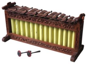 A BALINESE GAMELAN GENDER, 20TH CENTURY, the ornate scroll foliate carved frame housing 14 metal