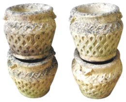A GROUP OF FOUR RECONSTITUTED STONE GARDEN POTS, tapered baluster form with lattice decorated