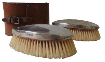 A PAIR OF SILVER MOUNTED CLOTHES BRUSHES, oval concave form, marked Walker & Hall, Sheffield, 1945