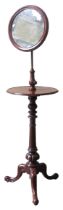 A VICTORIAN MAHOGANY SHAVING STAND, CIRCA 1860, adjustable circular mirror above a circular top,