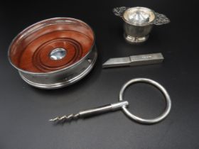 A SILVER RIM BOTTLE COASTER, RING HANDLE CORKSCREW, STRAINER AND CUP AND AN INGOT the coaster marked