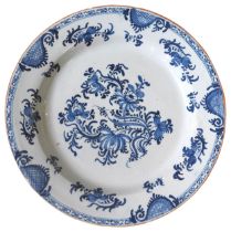 A 19TH CENTURY DELFT DISH, painted with flowering stems and fruiting vines, with scroll cartouches