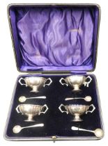 A BOXED SET OF FOUR SILVER SALT CELLARS, fluted tapered goblet form with twin ring handles, with